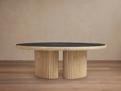Astor Round Coffee Table with ribbed oak-wrapped wood veneer base and black natural marble top, on wooden floor.