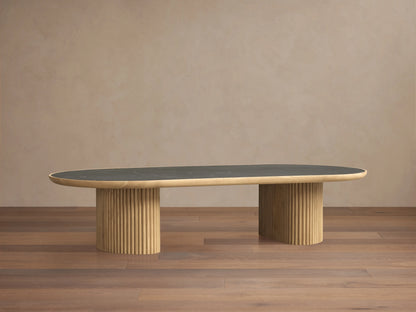 Astor Coffee Table with an oval marble top, supported by two cylindrical wooden bases wrapped in oak reeds, against a wooden floor.