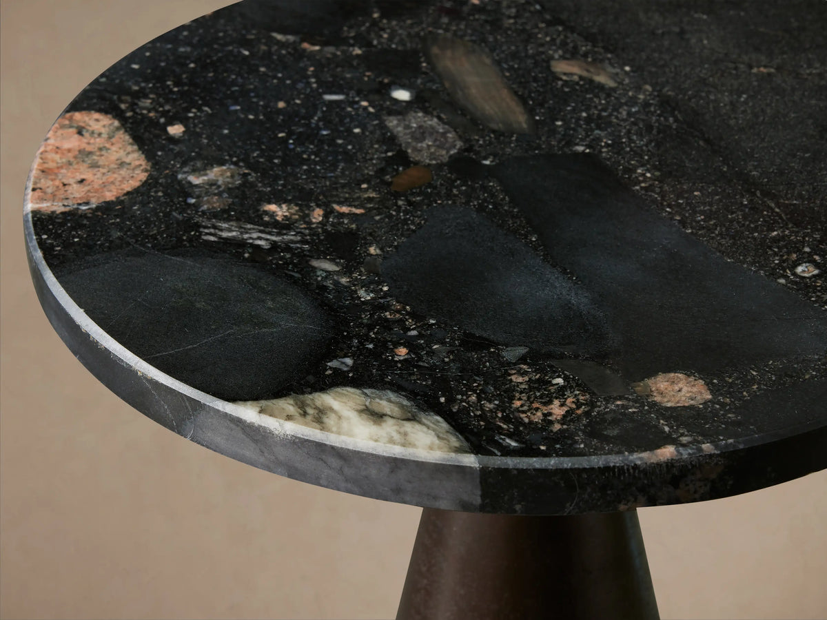 Beaufort Outdoor Martini Table with a dark bronze conical base and a round black top, standing upright on a wooden floor.