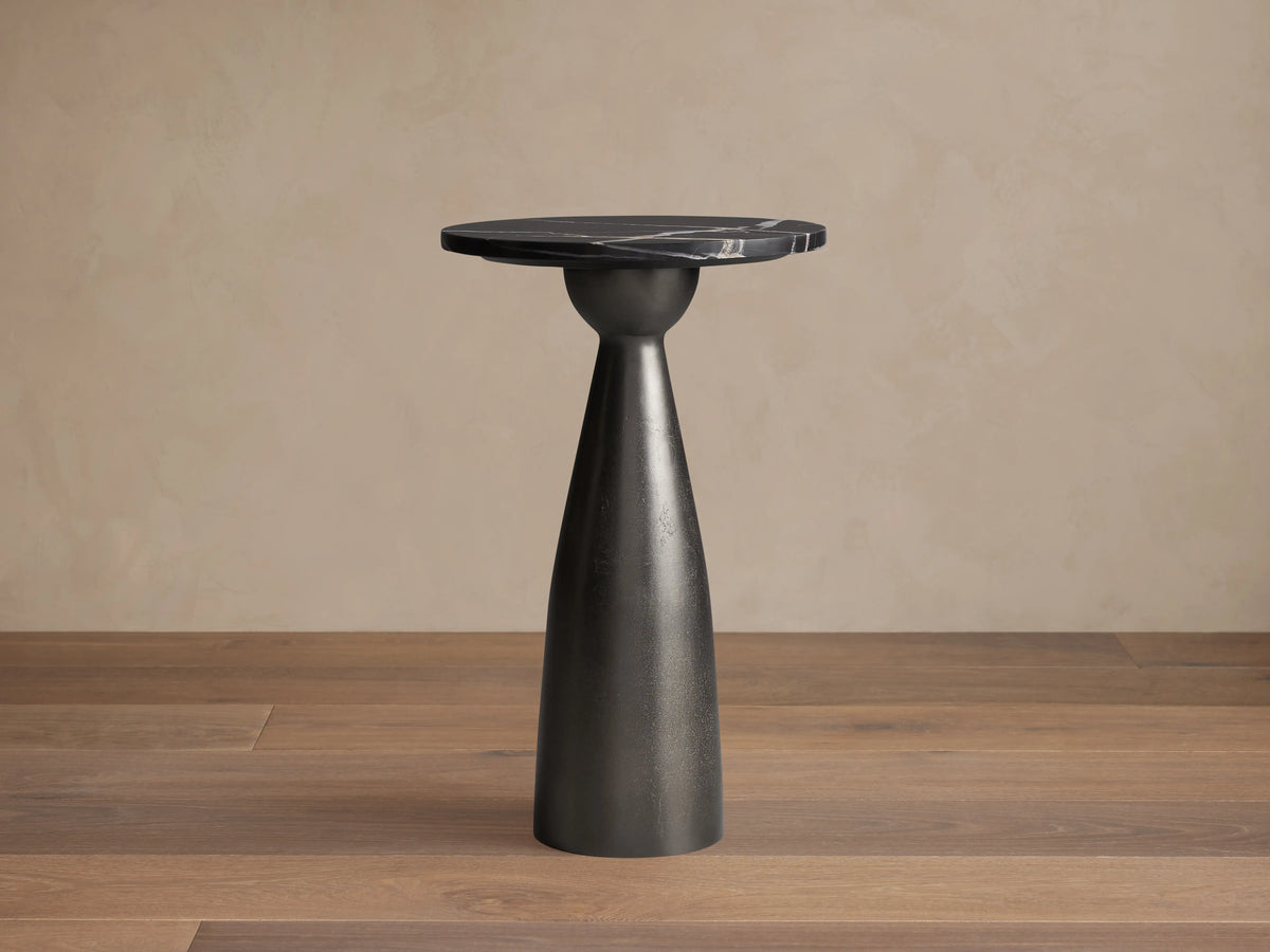 Beaufort Martini Table: round black marble top with white veins, tapered dark gray cast aluminum base.