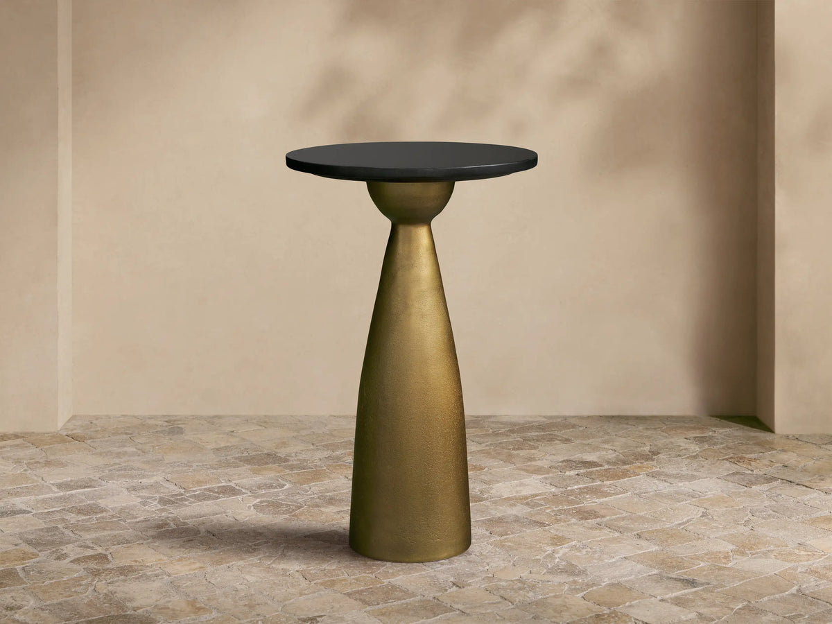 Front view of the Beaufort Martini Table with a round black granite top and a conical Antique Brass base.