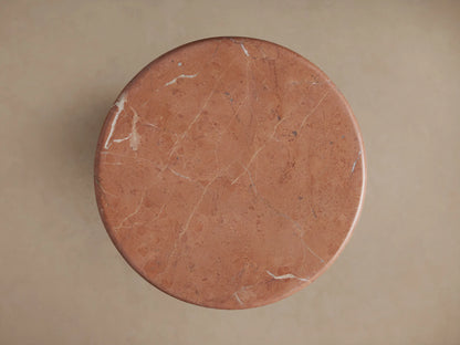 Close-up of Brecken Martini Table. Round, reddish-brown marble top with light veins, unique gold pattern, and tapered base.
