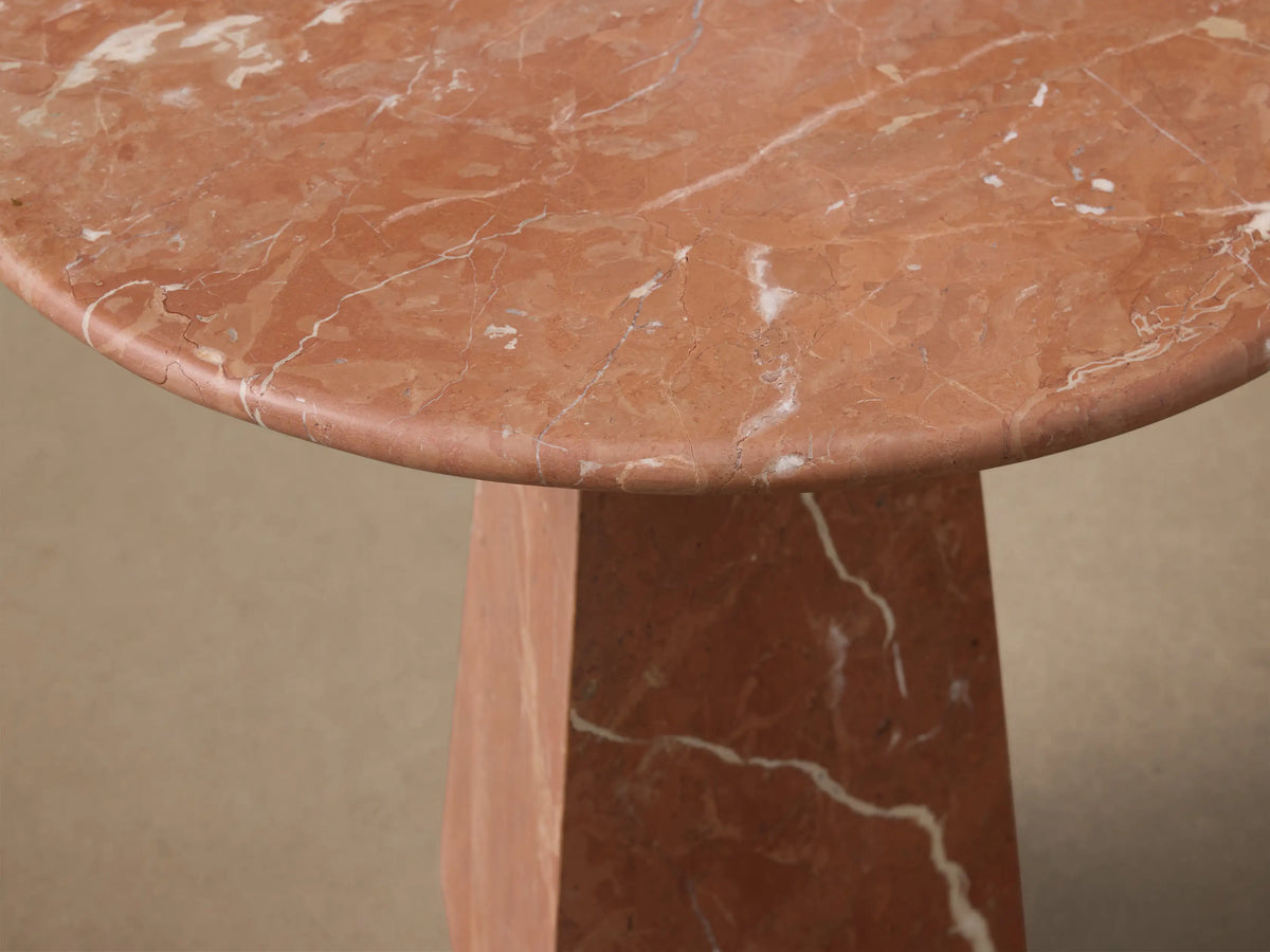 Front view of the reddish-brown marble Brecken End Table with a round top, tapering faceted base, and white veining.