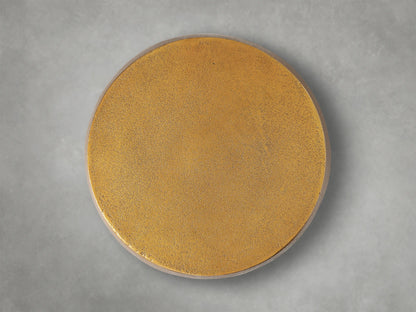 Close-up of a Hammered Drum End Table, showing its textured, antiqued metallic gold top edge and side with hand-pounded detailing.