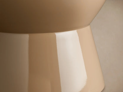 Beige Bridgers Lacquer Stool with a shiny, high-gloss finish. Features a cylindrical top and flared base on a wooden floor.
