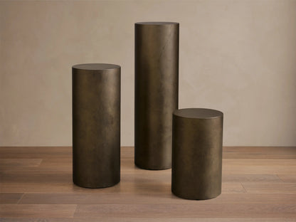 Close-up of the Bronze Bruna Pedestal, showing its cylindrical shape and rich, weathered metal patina.
