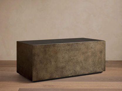 Front view of an aged bronze-toned rectangular coffee table, showing its dark top and mottled, textured sides.