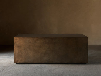 Front view of an aged bronze-toned rectangular coffee table, showing its dark top and mottled, textured sides.