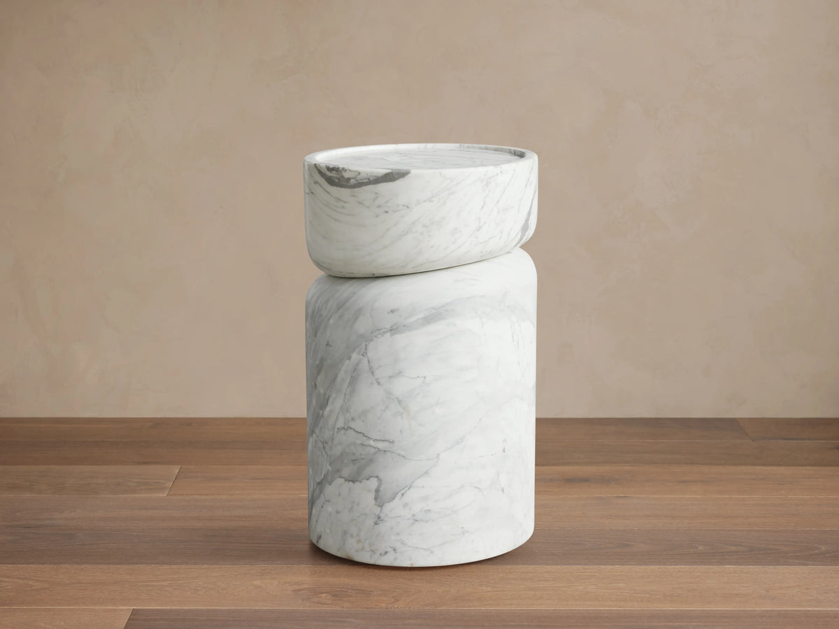Mayer Martini Table with a modern column silhouette, carved detailing, and gray veining on smooth, white natural stone.
