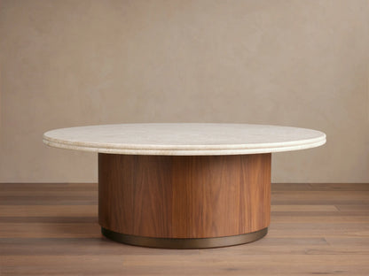 Caden Round Coffee Table with a cream stone top, walnut wood veneer cylindrical base, and antique bronze plinth on wood floor.