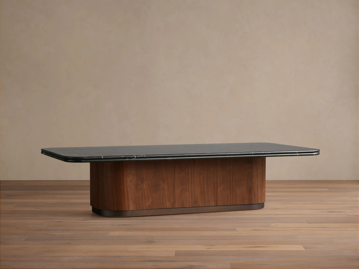Caden Coffee Table with rectangular Black Marquina stone top, rounded walnut wood veneer base, and antique bronze plinth.