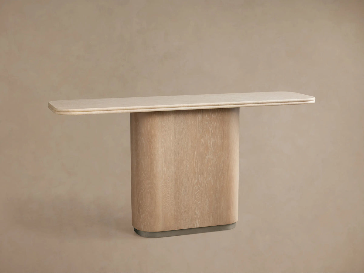 Caden Console Table with cream stone top, light sand oak curved base, and brushed nickel plinth against a taupe wall.