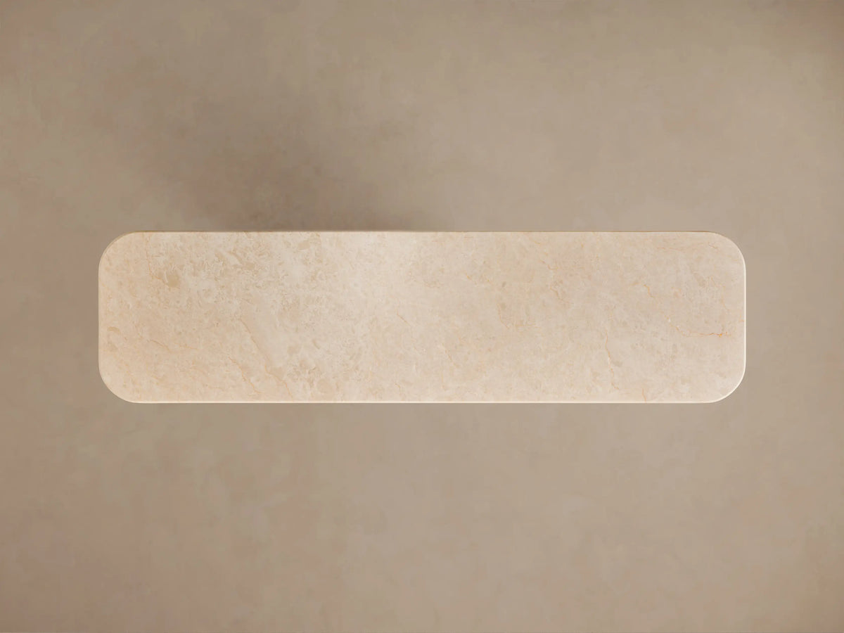 Close-up of Caden Console Table: Cream stone top with rounded, layered edge above a light sand oak wood veneer base.