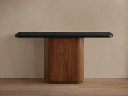 Angled close-up of Caden Console Table's black stone top with white veins and curved edge, next to a walnut wood base.