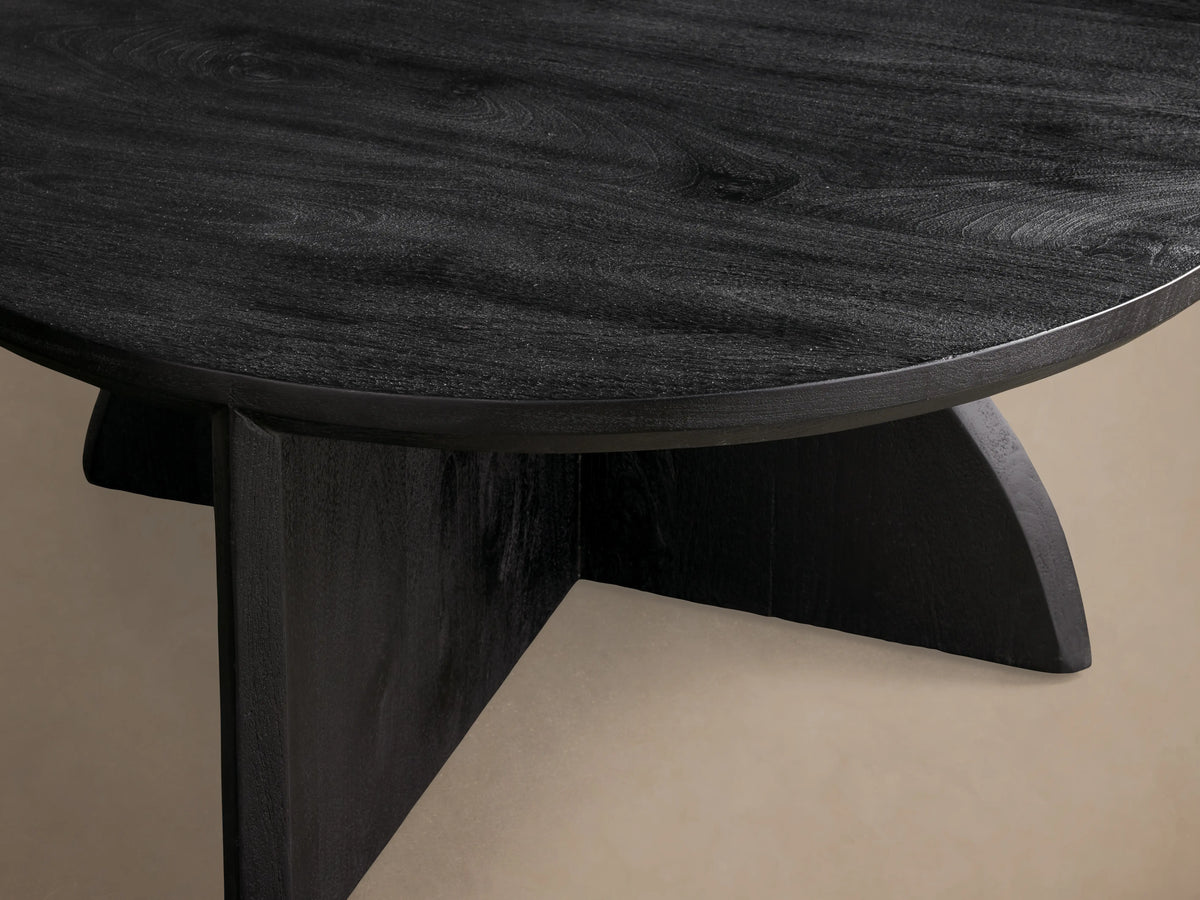 Round Calderone Coffee Table in matte black finish, crafted from solid mango wood, shown from above against a beige background.