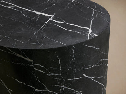 Cylindrical Cinzia Stone End Table made of black marble with white veining, featuring a smooth, polished surface on a wooden floor.