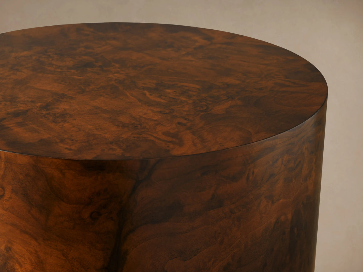 Cinzia Burl End Table with a round top and cylindrical body; features rich walnut burl wood veneer with unique swirling patterns.