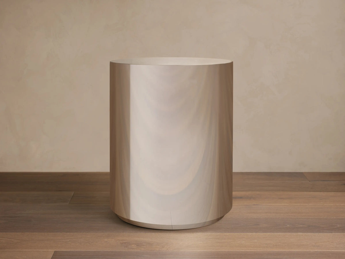 Front view of the Cinzia Chrome Round End Table, a cylindrical piece with a radiant, polished, mirror-like finish and a plinth-style base.