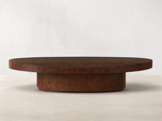 Cinzia Burl Round Coffee Table with a walnut burl wood veneer, low-profile silhouette, and plinth-style base on wooden floor.