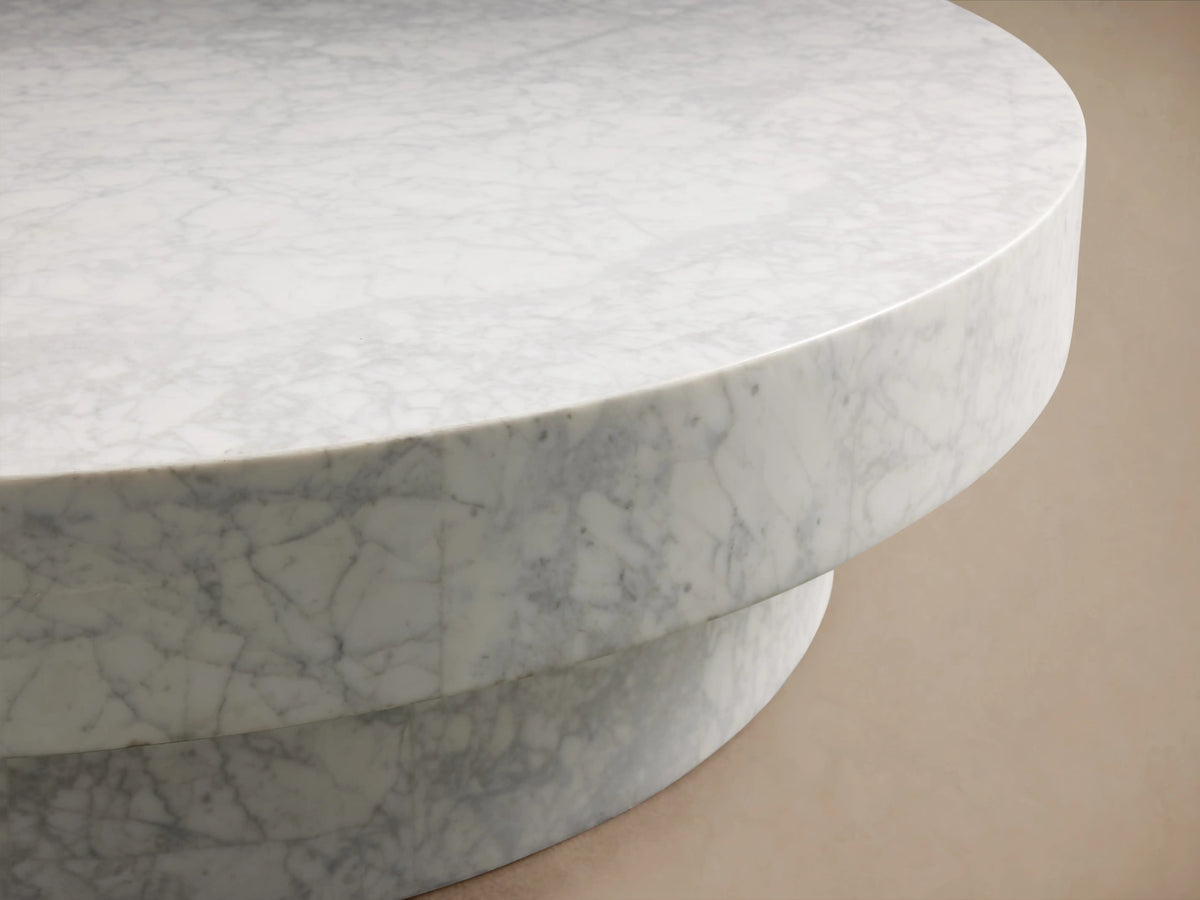 Cinzia Stone Round Coffee Table made of natural marble with visible veining, low-profile design, and cylindrical plinth base.