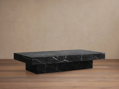Cinzia Stone Coffee Table in black marble with white veining, low-profile, rectangular top, plinth-style base, on wooden floor.