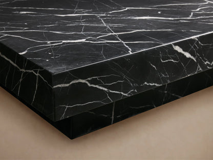 Cinzia Stone Coffee Table with a low-profile, rectangular black marble design, featuring white veining, on a plinth-style base.