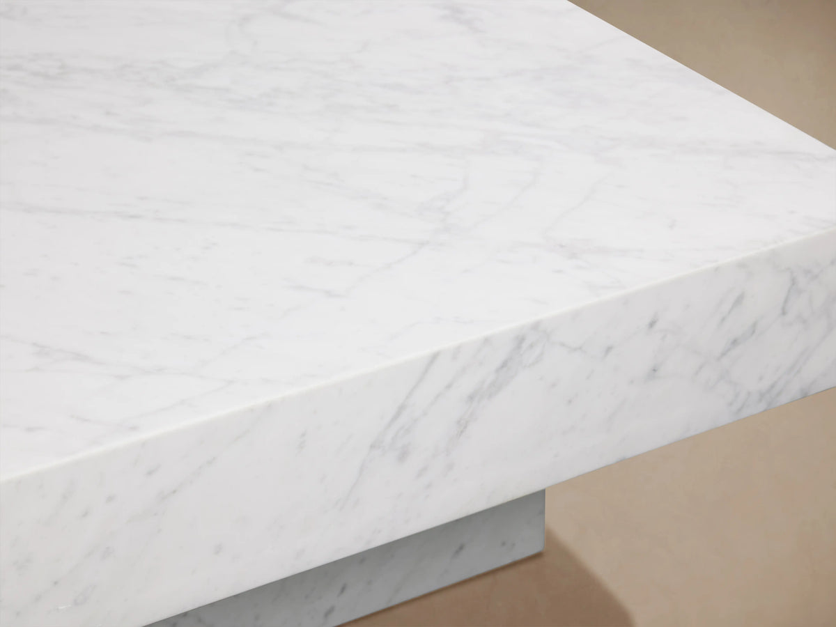 Cinzia Stone Coffee Table with natural white marble surface, subtle gray veining, and plinth-style base on a neutral background.