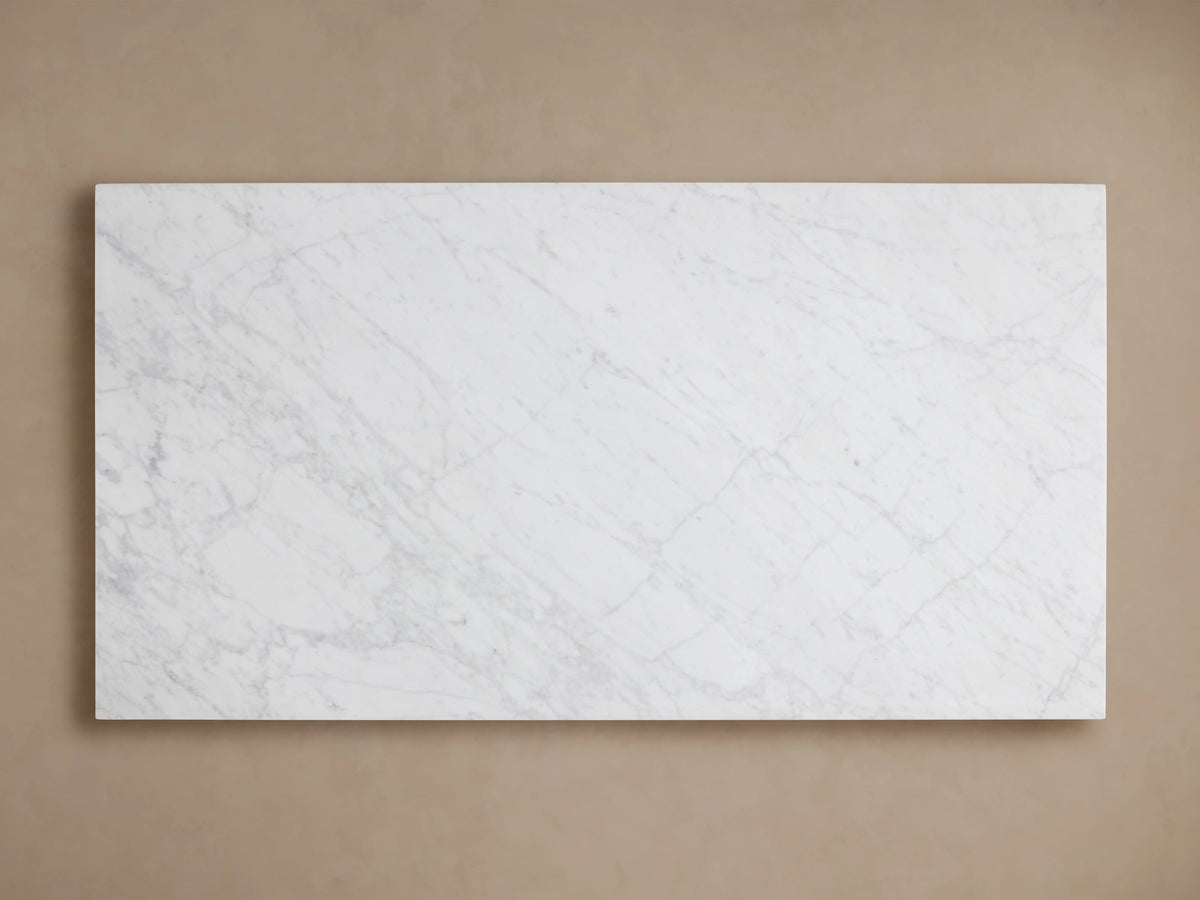 Cinzia Stone Coffee Table with a rectangular white marble surface, featuring subtle grey veining, set on a plinth-style base.