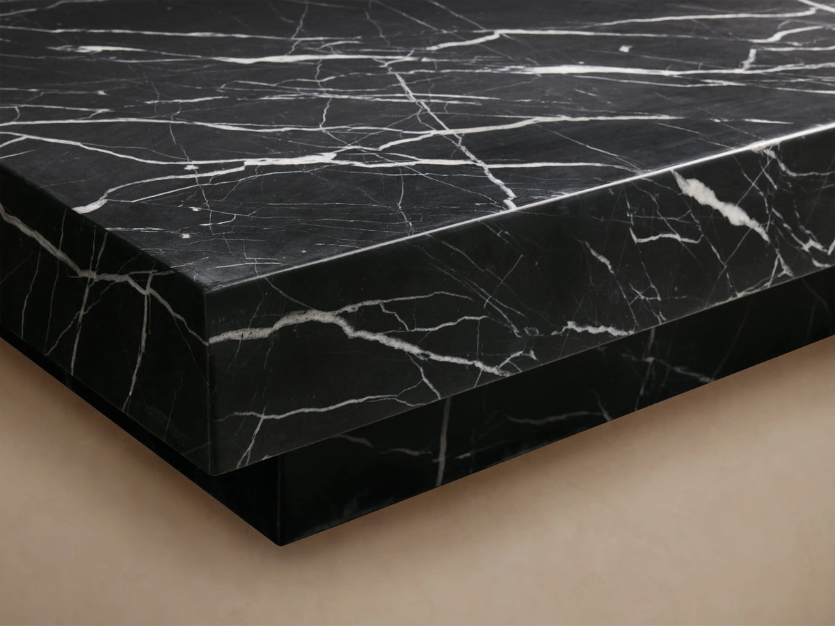Cinzia Stone Coffee Table: black marble with white veining, rectangular low-profile top on a plinth base, on wood floor.
