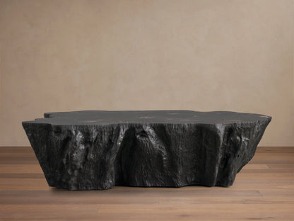 Clayhill Coffee Table with a polished, uneven petrified wood surface showcasing dark and light natural patterns, standing out against a beige background.