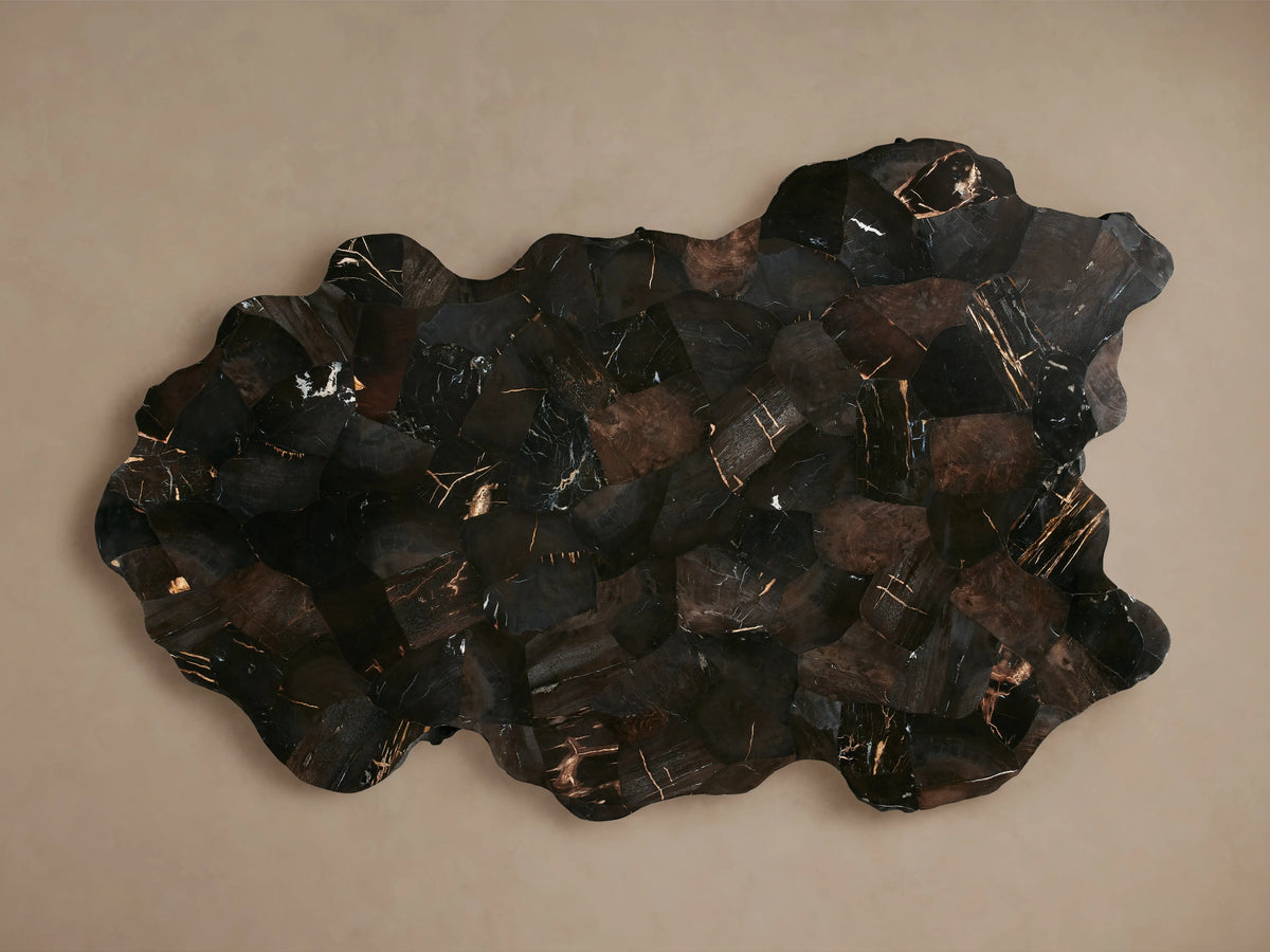 Clayhill Coffee Table with a rustic, dark petrified wood finish, irregular edges, and a polished surface, resting on a wooden floor.