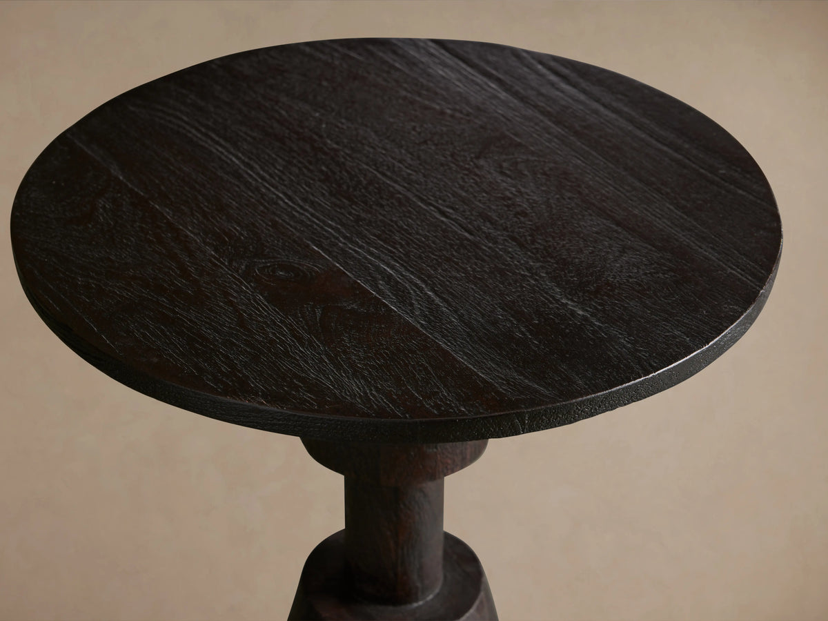 Caledonia Martini Table with round top, crafted from dark mango wood. Seen from above, showing wood grain and texture.