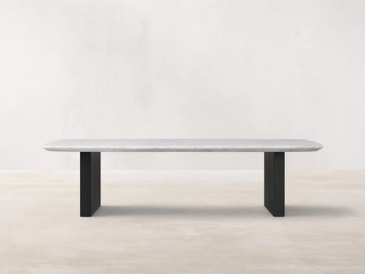 Saint Germain Stone Top Coffee Table with white marble top and dark wooden base, set on wood floor against beige wall.