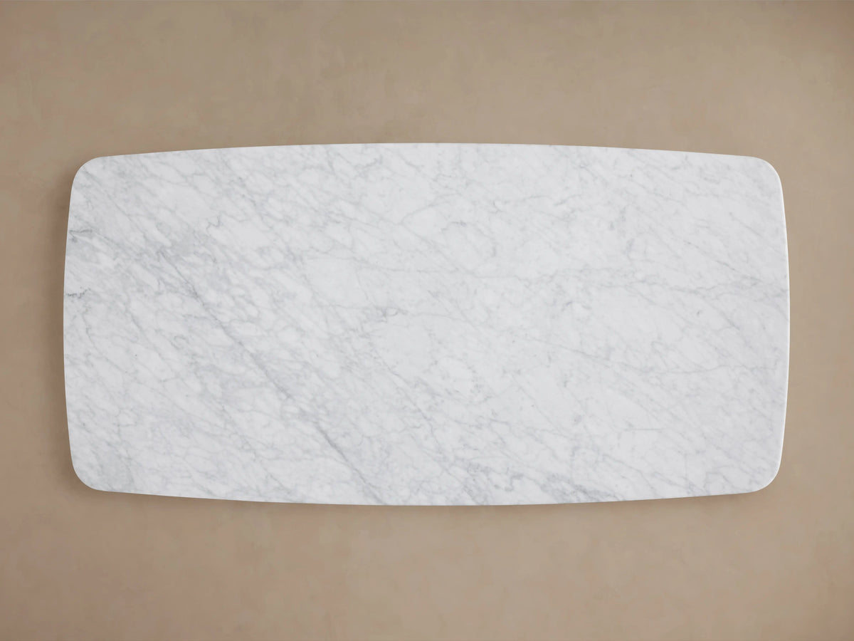 Saint Germain Stone Top Coffee Table with white marble top and dark wooden base, set on wood floor against beige wall.