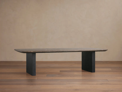 Stone top coffee table with a dark espresso brown stone surface and rectangular wooden base in ebony finish, placed on a wooden floor against a beige wall.