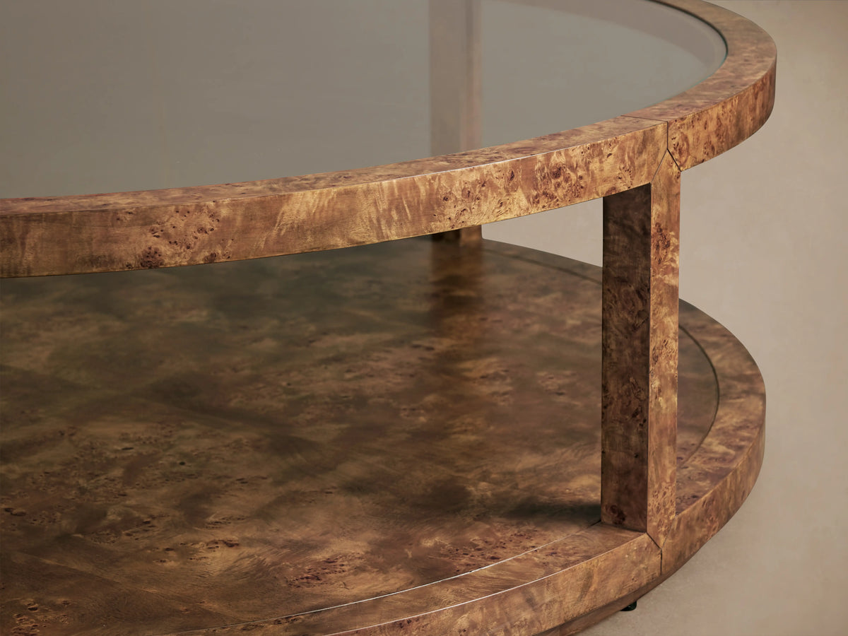 Corey Round Coffee Table in swirling mappa burl wood, featuring a glossy top, round lower shelf, and cylindrical supports.