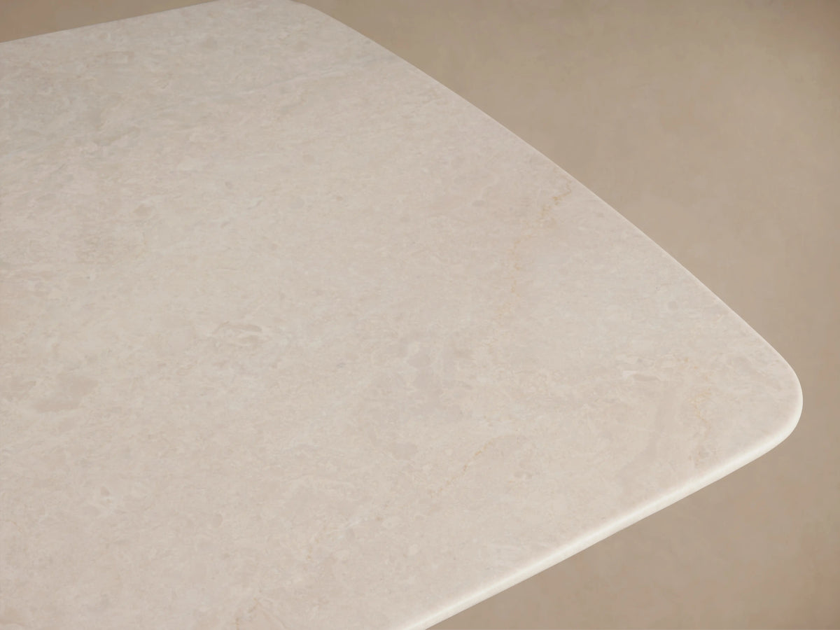 Saint Germain Stone Top Coffee Table featuring a light-colored stone tabletop, supported by two dark wood rectangular legs on hardwood floor.