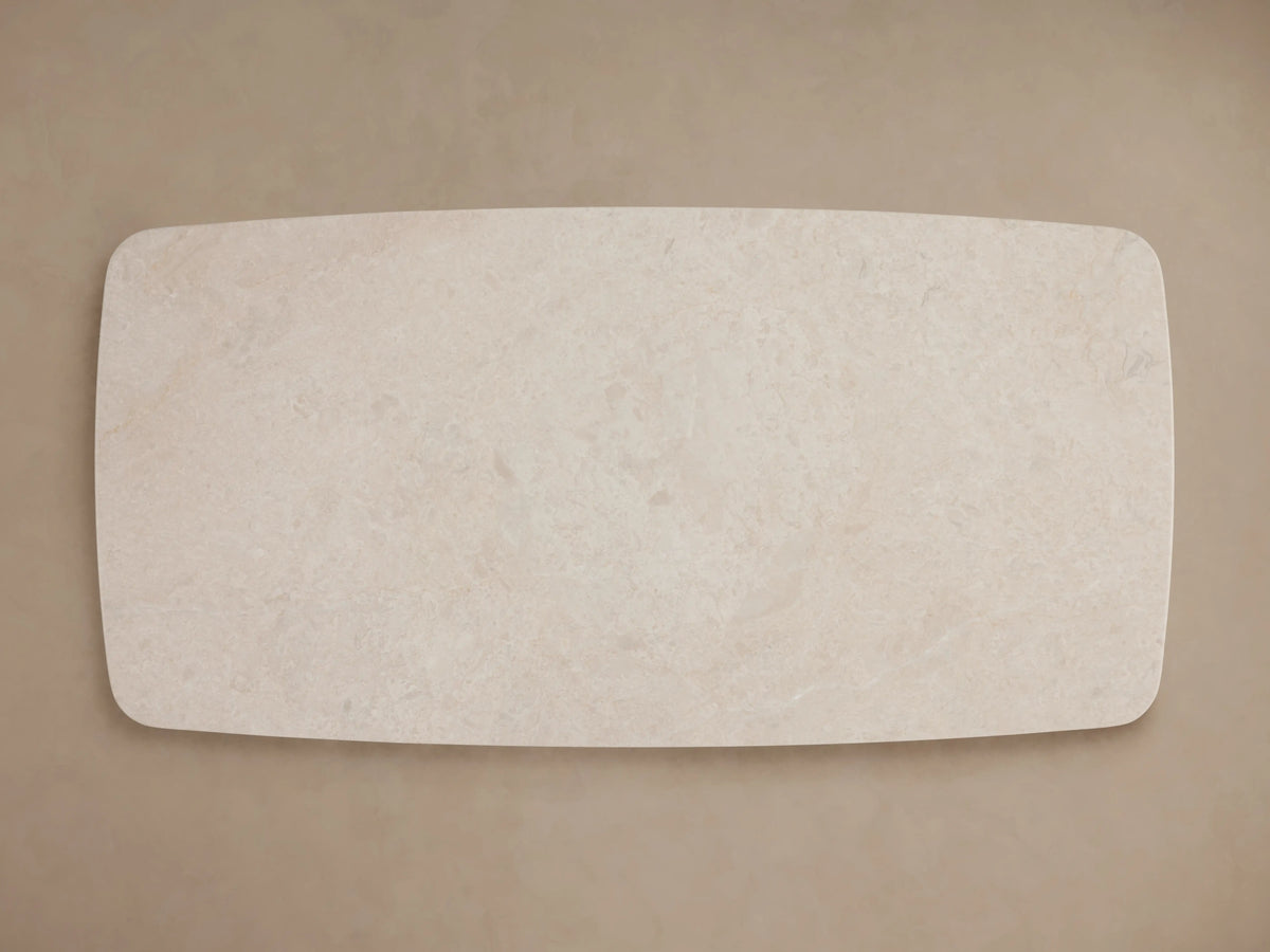 Rectangular tabletop in cream marble with subtle swirling patterns and natural veining, set on a neutral background.