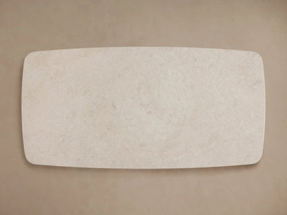 Saint Germain Stone Coffee Table with cream marble top and two dark wooden Dauphine bases on wood floor, beige wall.