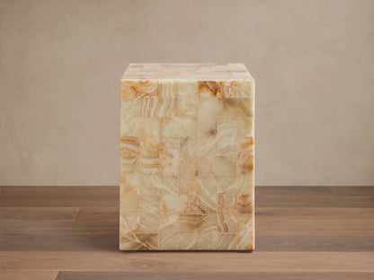 Dasha Onyx Stool with square shape, featuring a tiled design in ivory, light green, and rust tones on a wooden floor.