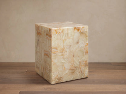 Dasha Onyx Stool with square shape, featuring a tiled design in ivory, light green, and rust tones on a wooden floor.