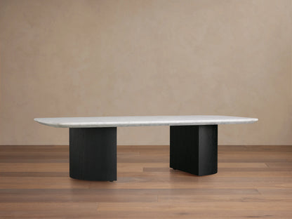 Saint Germain Stone Coffee Table with a long, oval Carrara marble top, cream color, on two solid, rectangular, dark ebony bases.