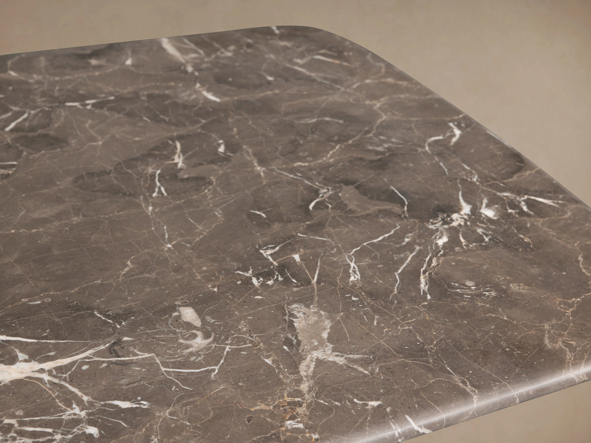 Saint Germain Coffee Table with a dark espresso brown stone top and solid wood Dauphine base, set on a wooden floor.