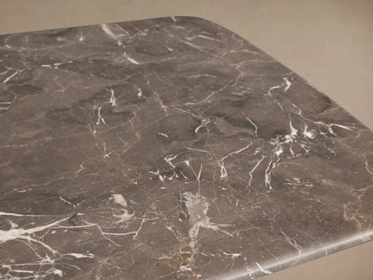 Saint Germain Coffee Table with a dark espresso brown stone top and solid wood Dauphine base, set on a wooden floor.