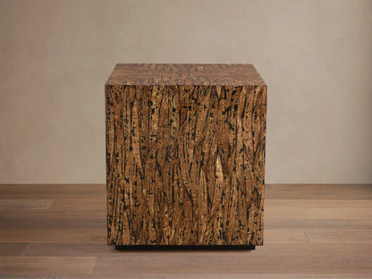 Desi End Table: cube-shaped, natural kapok wood veneer with marbled brown grain and distinct black resin accents.