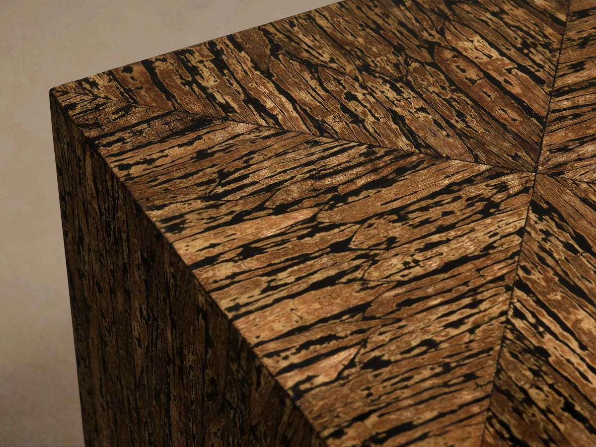 Desi End Table: cube-shaped, natural kapok wood veneer with marbled brown grain and distinct black resin accents.