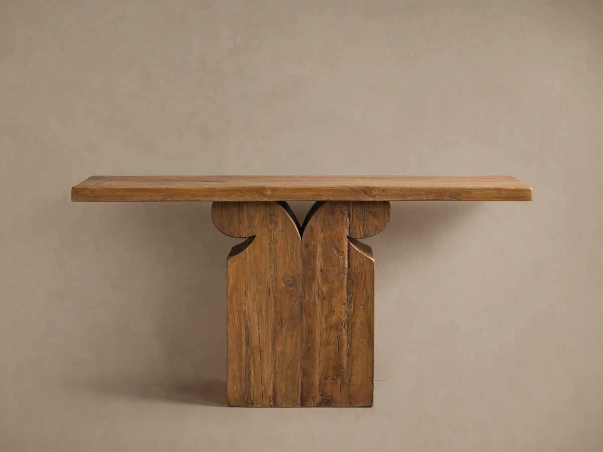Dumai Console Table with a rustic wooden finish, featuring a thick rectangular top and intricate carved pedestal base.