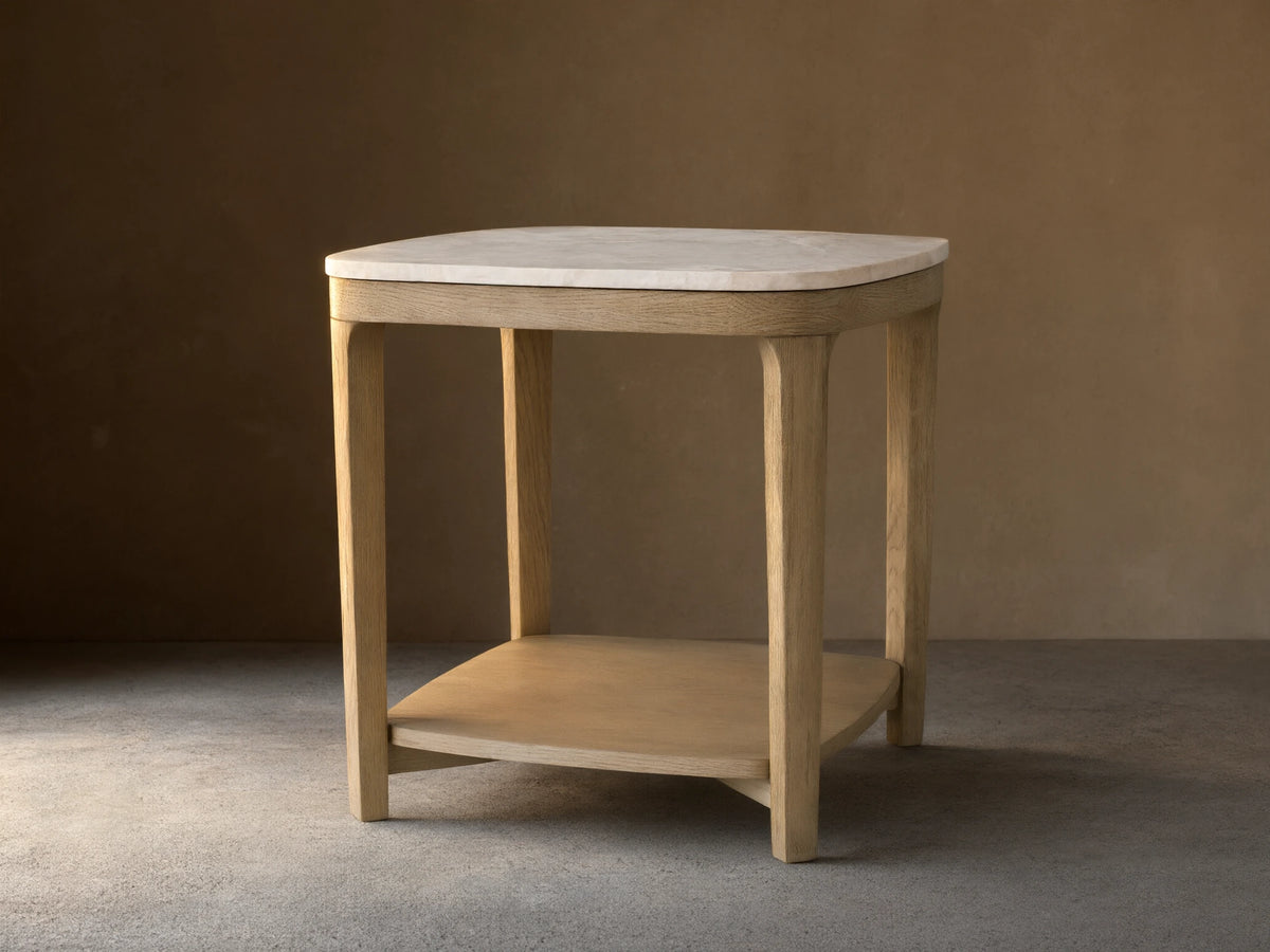Danny End Table with ivory-toned marble top and oak wood frame in fawn finish on a wooden floor.