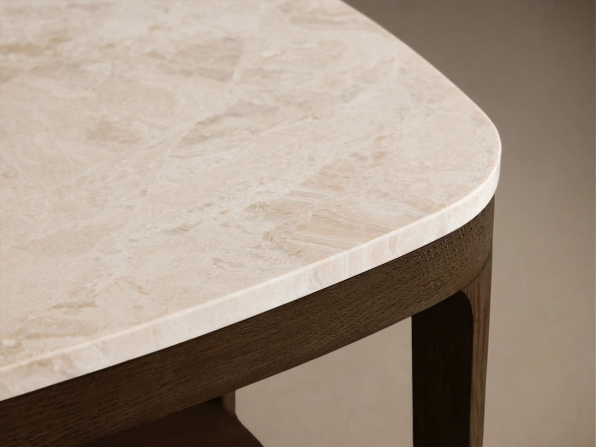 Close-up of the corner of the Beige Oasis Marble Coffee Table, showing light beige marble with natural veining and a dark brown wood frame.