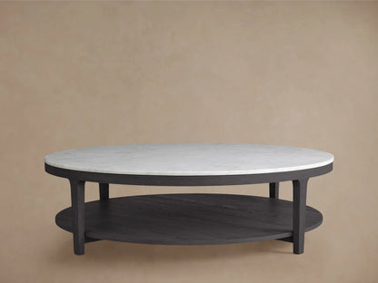 Round coffee table with an ebony-finished oak wood base and a white Carrara marble top, set against a beige background.
